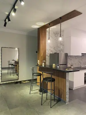 a kitchen with a counter with chairs and a mirror at DiveZen Sea View apartment in Quseir