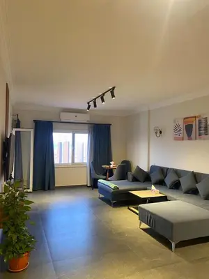 a living room with blue couches and a table at DiveZen Sea View apartment in Quseir