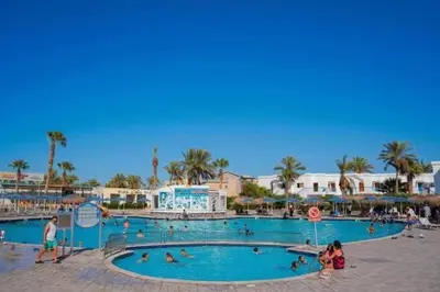 a swimming pool at a resort with people in it at Mirage Aqua Park Villa in Hurghada