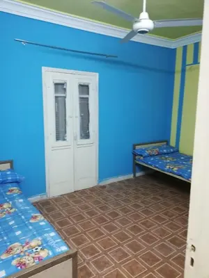 a room with two beds and a blue wall at Nasser in Jazīrat Aswān
