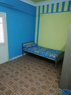a room with a bed with a blue wall at Nasser in Jazīrat Aswān
