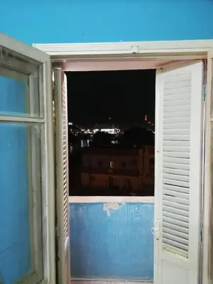 a window with a view of a city at night at Nasser in Jazīrat Aswān