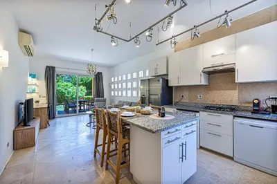 a kitchen with white cabinets and a large island at Townhouse South Marina in Hurghada