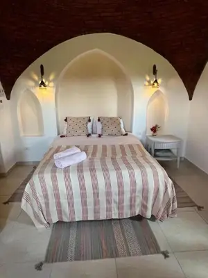 a bedroom with a large bed with two pillows at Lady of the Sun Guesthouse in Luxor