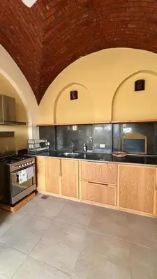a large kitchen with wooden cabinets and a brick ceiling at Lady of the Sun Guesthouse in Luxor