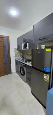 a kitchen with a refrigerator and a stove top oven at Tiba Golden Red Sea Coral Hurghada in Hurghada