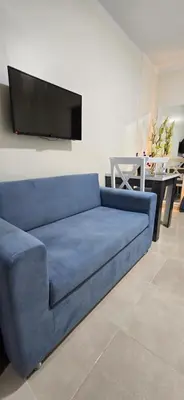 a blue couch in a living room with a flat screen tv at Tiba Golden Red Sea Coral Hurghada in Hurghada