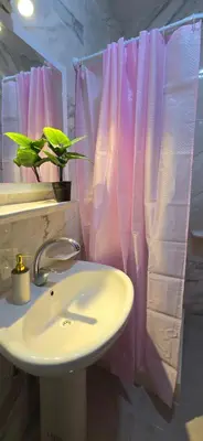 a bathroom with a sink and a pink shower curtain at Tiba Golden Sun-kissed Hurghada in Hurghada