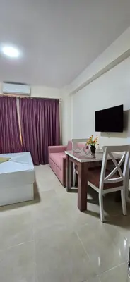 a living room with a pink couch and a table at Tiba Golden Sun-kissed Hurghada in Hurghada