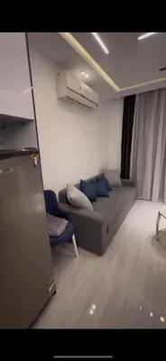 a living room with a couch and a blue chair at Flat In Elhambra in Hurghada