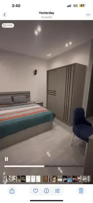a bedroom with a bed and a blue chair at Flat In Elhambra in Hurghada