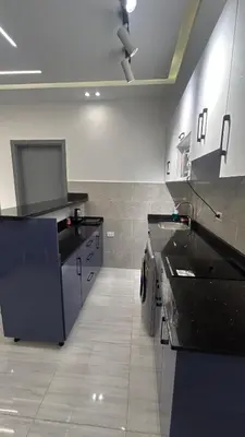 a large kitchen with black counter tops in a room at Flat In Elhambra in Hurghada