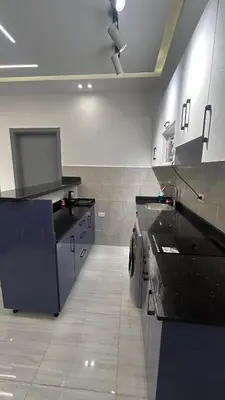 a large kitchen with black counter tops in a room at Flat In Elhambra in Hurghada