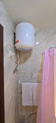 a bathroom with a white tank and towels on a wall at Tiba Golden White Lagoon Hurghada in Hurghada