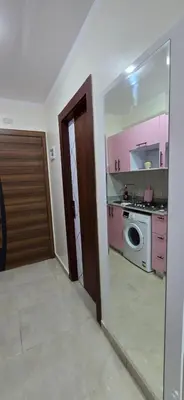 a kitchen with pink cabinets and a washer and dryer at Tiba Golden Whire Sands Hurghada in Hurghada