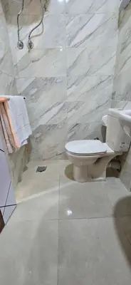 a bathroom with a toilet and a stone wall at Tiba Golden Whire Sands Hurghada in Hurghada