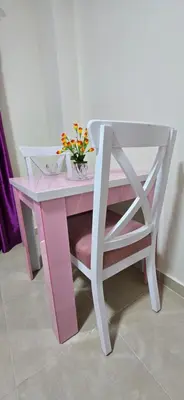 a pink desk with a vase of flowers on it at Tiba Golden Whire Sands Hurghada in Hurghada