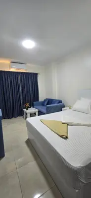 a bedroom with a large bed and a blue couch at Tiba Golden Royal Blue Hurghada in Hurghada