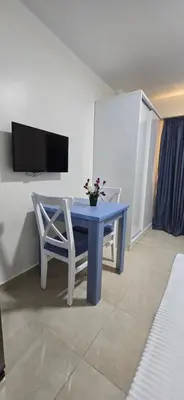 a blue table with two chairs and a tv at Tiba Golden Royal Blue Hurghada in Hurghada
