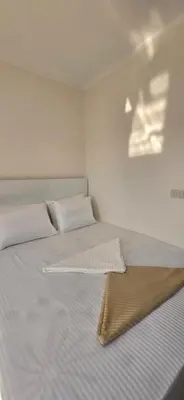 a bed with white sheets and pillows in a room at Tiba Golden Royal Blue Hurghada in Hurghada
