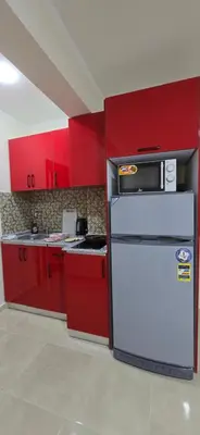 a kitchen with red cabinets and a white refrigerator at Tiba Golden Lagoon Hurghada in Hurghada