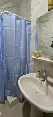 a bathroom with a sink and a blue shower curtain at Tiba Golden Private Beach Hurghada in Hurghada