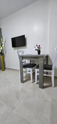 a table with a chair and a television on a wall at Tiba Golden Private Beach Hurghada in Hurghada