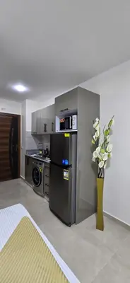 a kitchen with a refrigerator and a vase of flowers at Tiba Golden Private Beach Hurghada in Hurghada