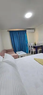 a bedroom with a large white bed and a couch at Tiba Golden Blue Oasis Hurghada in Hurghada