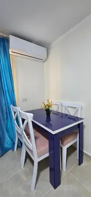 a purple table with two chairs and a vase with flowers at Tiba Golden Blue Oasis Hurghada in Hurghada