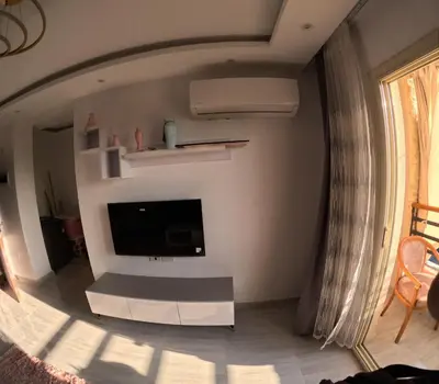 a living room with a flat screen tv on a wall at Alhambara compound in Hurghada