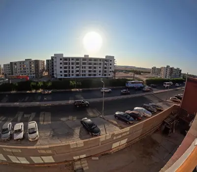 a parking lot with cars parked in front of a building at Alhambara compound in Hurghada
