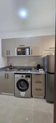 a kitchen with a washing machine and a refrigerator at Tiba Golden Sand Dune Hurghada in Hurghada