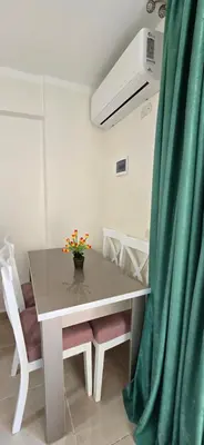 a dining room with a table and a green curtain at Tiba Golden Sand Dune Hurghada in Hurghada