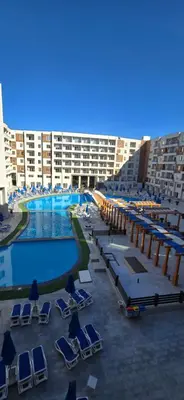 a large hotel with a swimming pool and lounge chairs at Tiba Golden Crystal Water Hurghada in Hurghada