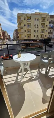 a white table and two chairs on a balcony at Tiba Golden Blue Coral Hurghada in Hurghada