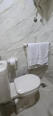a bathroom with a toilet and towels on a wall at Tiba Golden Blue Coral Hurghada in Hurghada