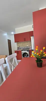 a kitchen with red cabinets and a red table with flowers on it at Tiba Golden Crystal Oasis Hurghada in Hurghada