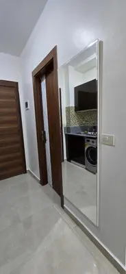 a room with a mirror and a kitchen with a microwave at Tiba Golden Golden Coast Hurghada in Hurghada
