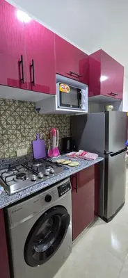 a kitchen with a stove and a washing machine at Tiba Golden Sea Harmony Hurghada in Hurghada