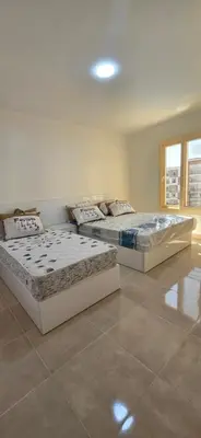 two beds sitting in a room with at Tiba Golden Serenity Hurghada in Hurghada