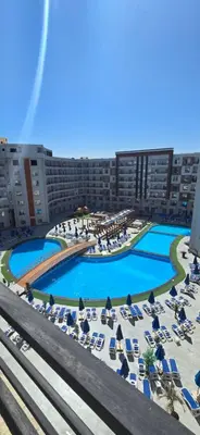 an aerial view of a hotel with chairs and pools at Tiba Golden Serenity Hurghada in Hurghada