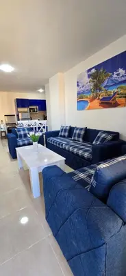 a living room with blue couches and a white table at Tiba Golden Sun and Sea Hurghada in Hurghada