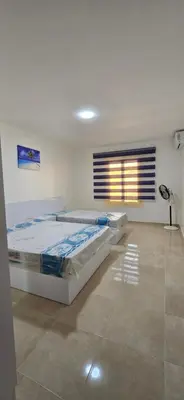a bedroom with two beds and a window at Tiba Golden Sun and Sea Hurghada in Hurghada