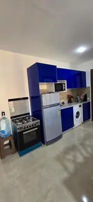 a kitchen with blue cabinets and a stove and refrigerator at Tiba Golden Sun and Sea Hurghada in Hurghada