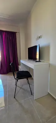 a desk with a computer and a chair in a room at Tiba Golden Sand Palace Hurghada in Hurghada