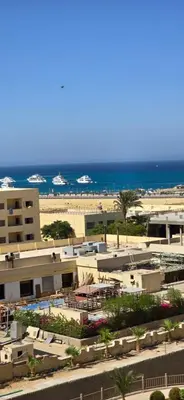 a view of a beach with a building and the ocean at Tiba Golden Sand Palace Hurghada in Hurghada