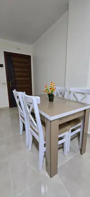 a table with white chairs and a vase with flowers on it at Tiba Golden Amber Sands Hurghada in Hurghada