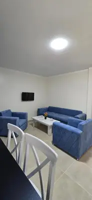a living room with a blue couch and a table at Tiba Golden Oasis Royale Hurghada in Hurghada