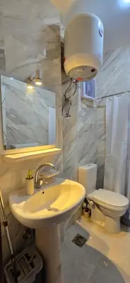a bathroom with a white sink and a toilet at Tiba Golden Oasis Royale Hurghada in Hurghada